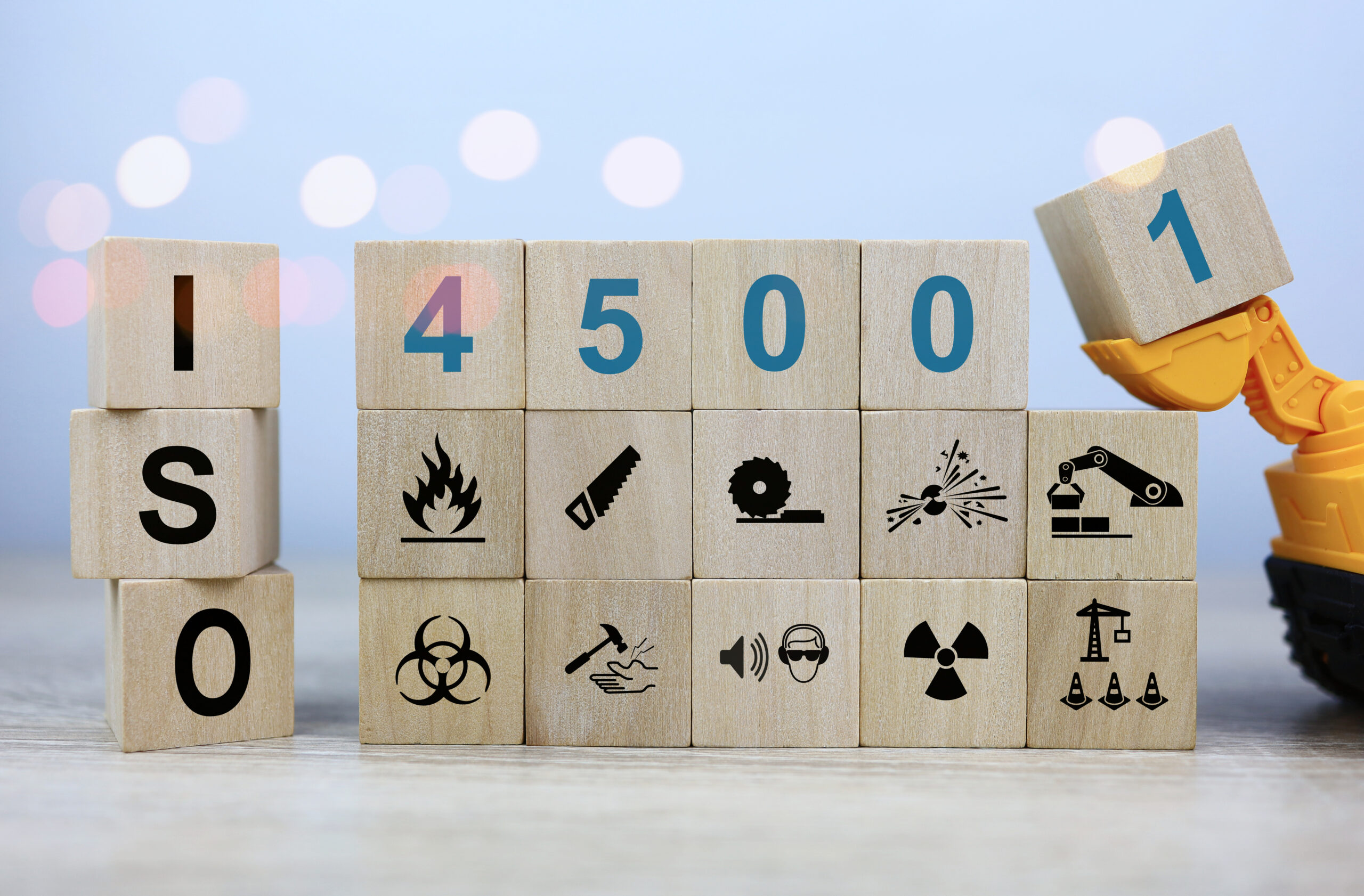 iso 45001 is a workplace safety standard that deals with the health and safety of employees. Standard icons and safety symbols on square wooden dice.